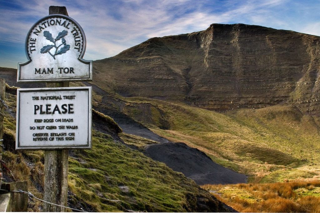 a scenic view of the peak district's mam tor with signage
