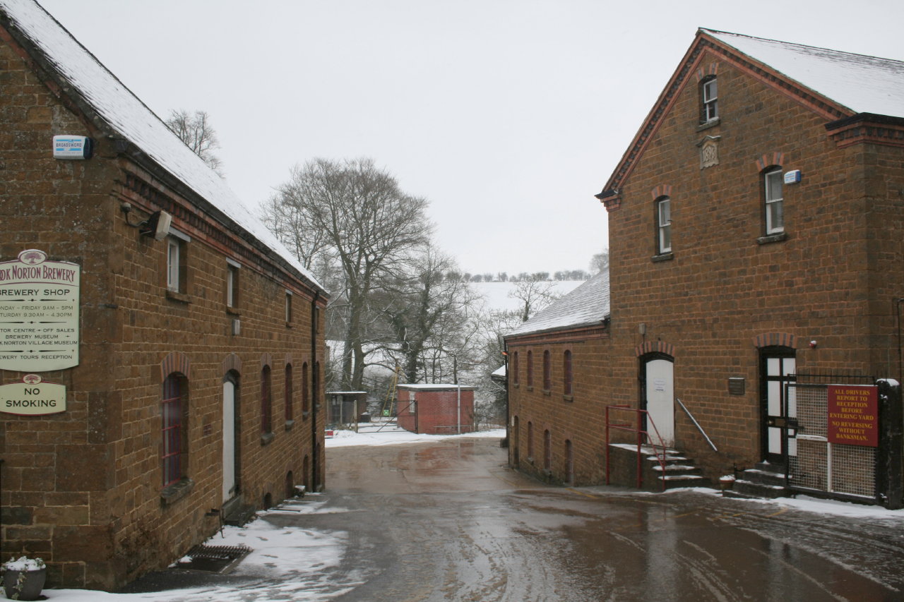 Stone brewery buildings around a snow-covered yard