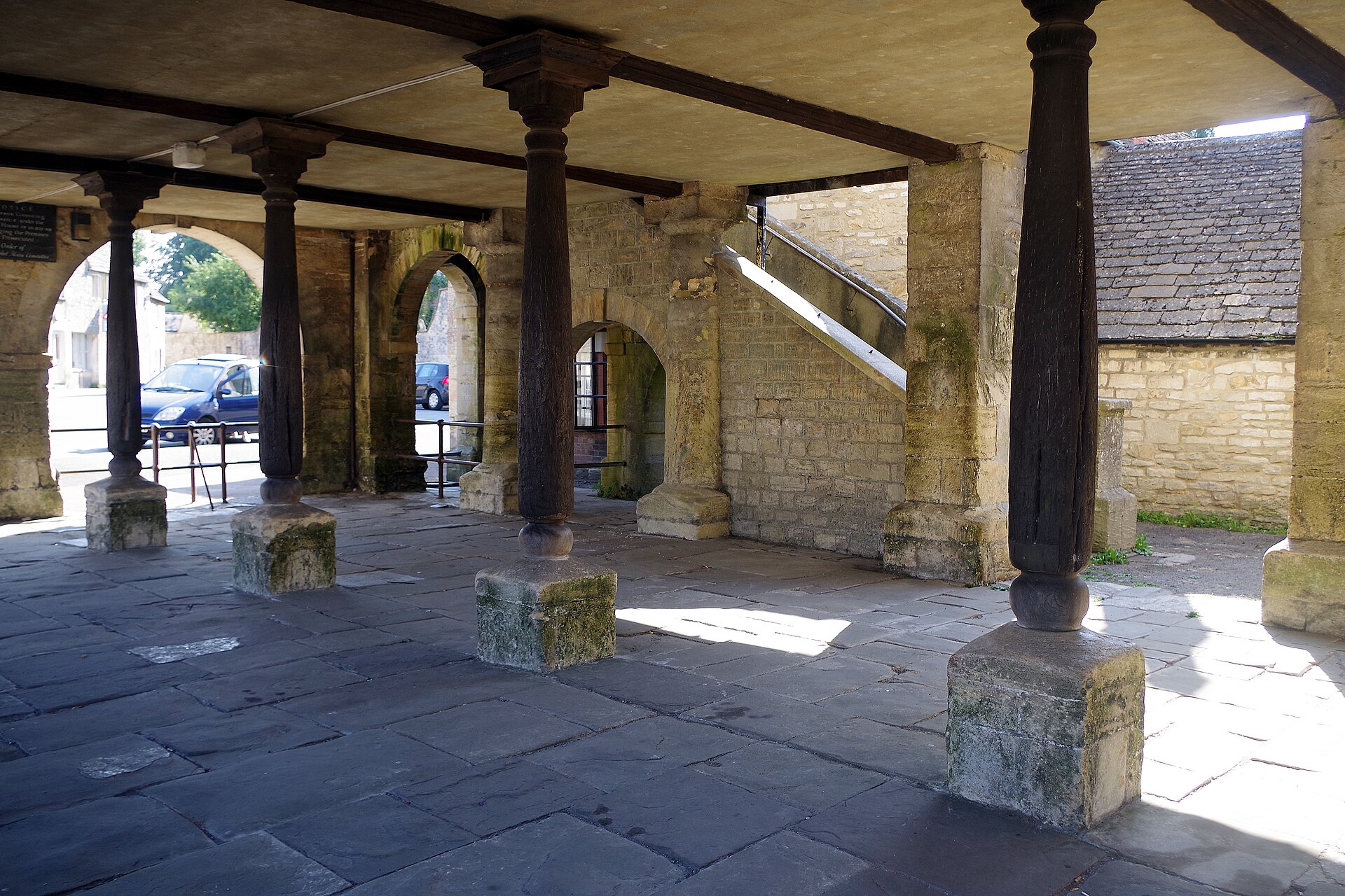 Stone arches, timber posts and stairs beneath Minchinhampton Market House