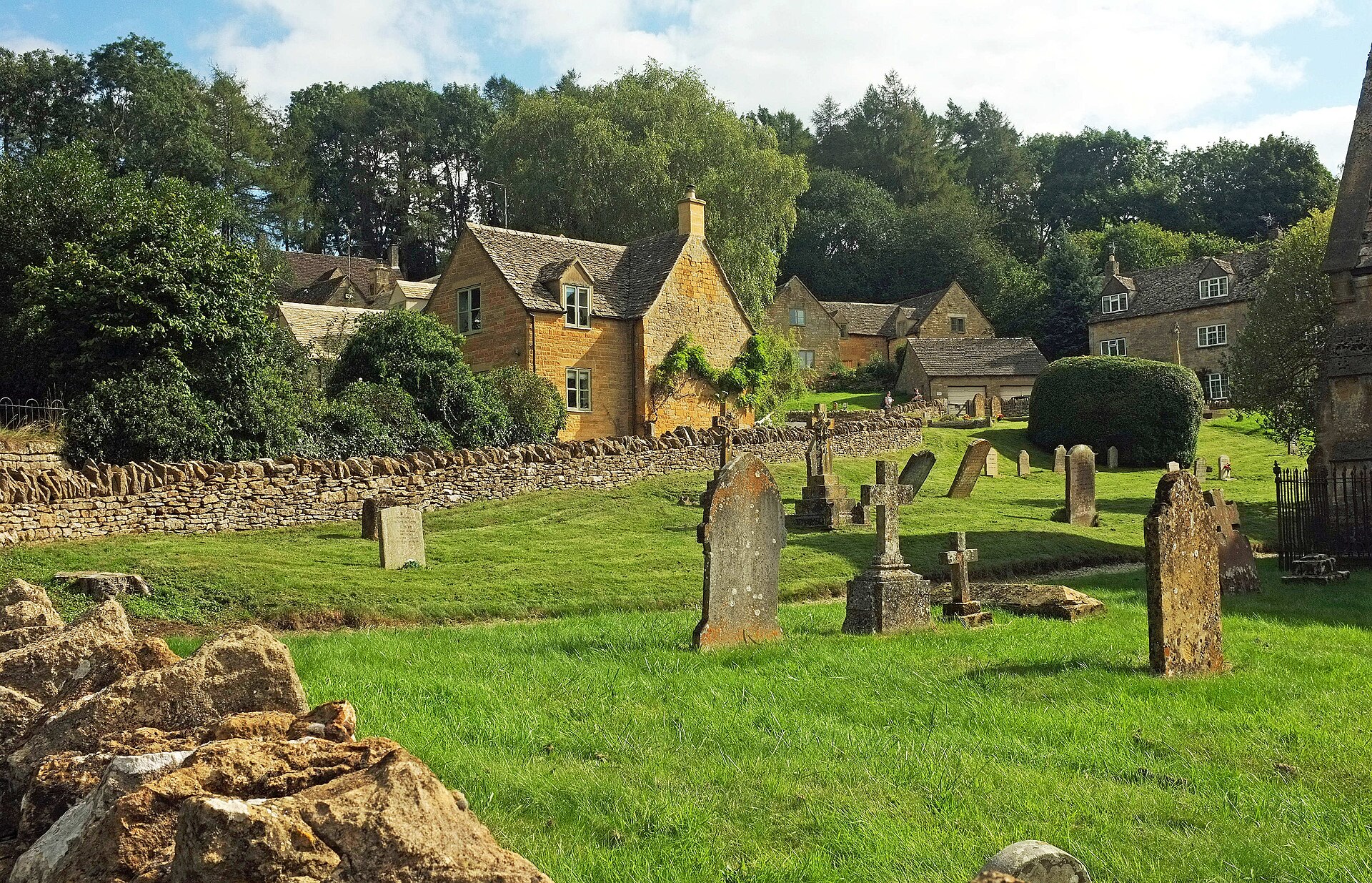 Stone wall and trees in Snowshill churchyard