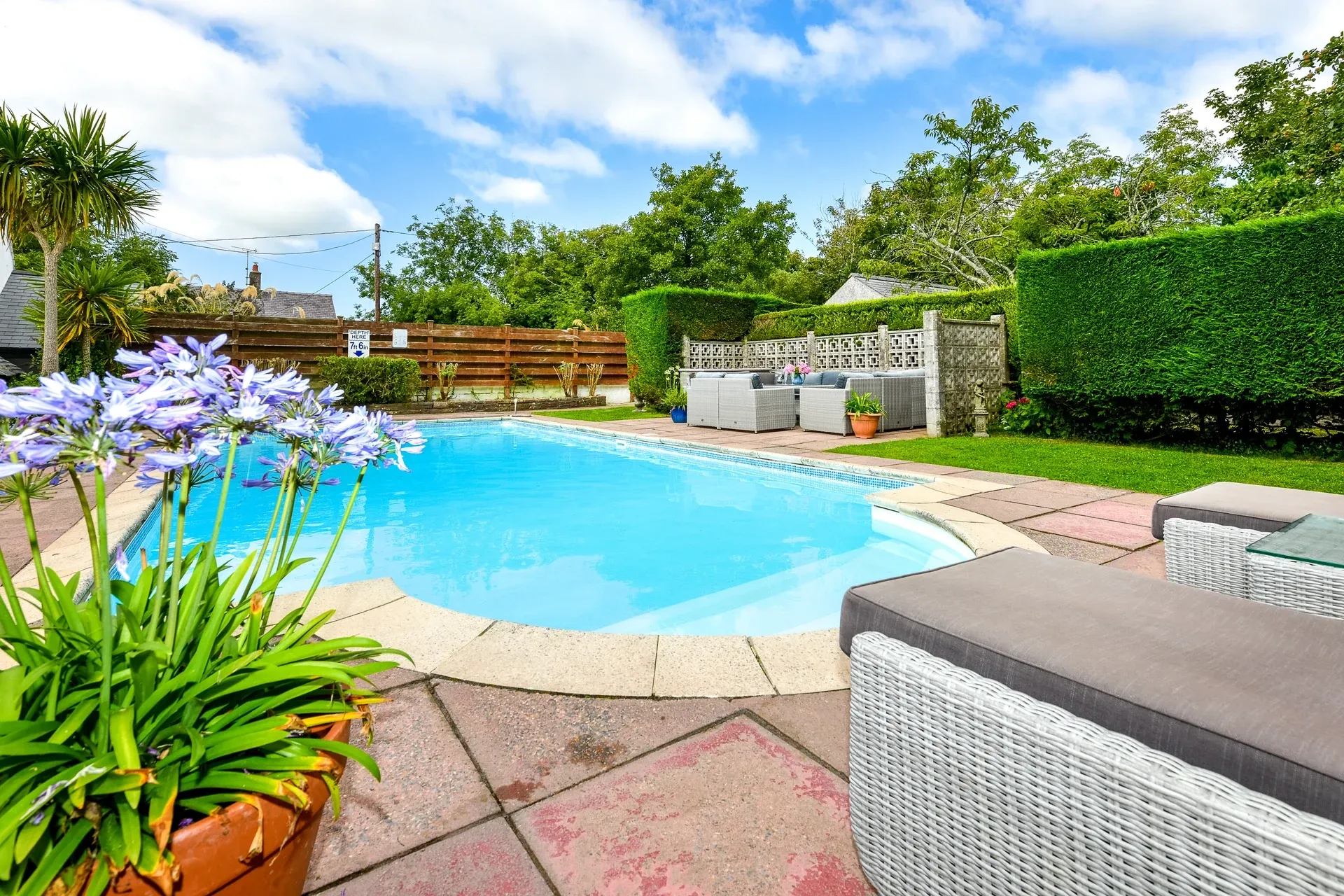 Swimming pool surrounded by flowers at Plas Newydd